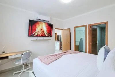 a bedroom with a bed and a desk and a tv at Cozy, Centric 1BR Condo, Pool in Los Prados