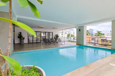 a swimming pool with a view of a building at Cozy, Centric 1BR Condo, Pool in Los Prados