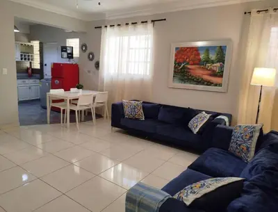 a living room with a blue couch and a table at Apartamento próximo al centro médico HOMS in Hato Mayor
