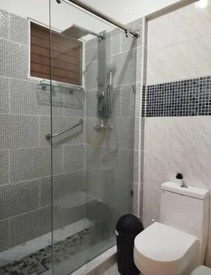 a bathroom with a glass shower with a toilet at Apartamento próximo al centro médico HOMS in Hato Mayor