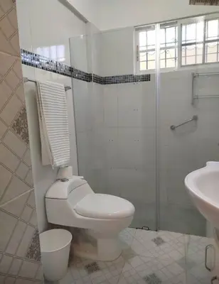 a white bathroom with a toilet and a sink at Apartamento próximo al centro médico HOMS in Hato Mayor
