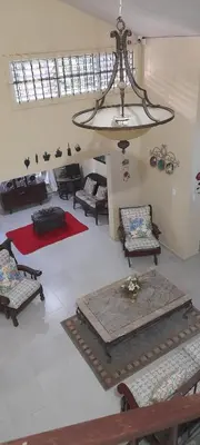 a living room with chairs and a chandelier at Villabenedetta santo domingo in Varía
