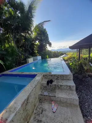 a pair of flip flops next to a swimming pool at Villabenedetta santo domingo in Varía