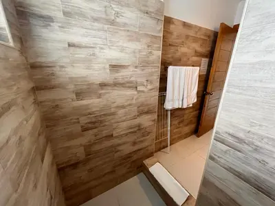 a bathroom with a shower with wooden walls at Residencial Paraíso A101 in Bayahibe