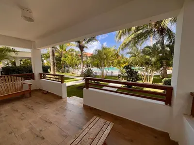a porch with a view of the ocean and palm trees at Residencial Paraíso A101 in Bayahibe