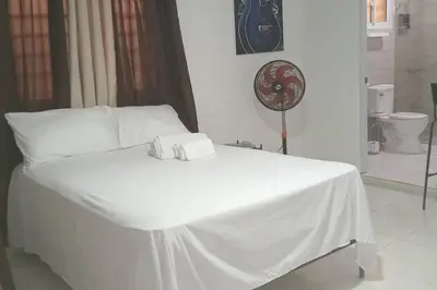 a white bed in a room with a toilet at Aparta estudio 2 El Cacique, próximo malecón SD in Santo Domingo