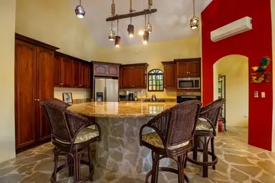 a kitchen with a large island with chairs around it at Cabarete Oceanview Villa Pool Oasis Beach Access in Cafemba