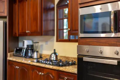 a kitchen with a stove and a microwave at Cabarete Oceanview Villa Pool Oasis Beach Access in Cafemba