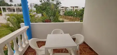a white table and chairs on a balcony at Charmant appartement cuisine 1 chambre AC Bonita in El Hoyo del Cacao