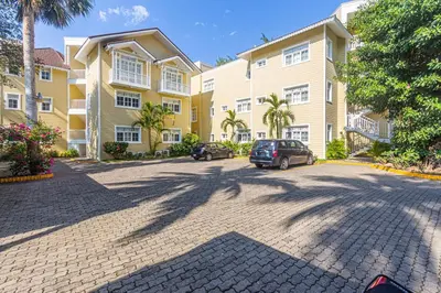 a large apartment complex with cars parked in a driveway at Los Balcones, Sosua, Ocean Front! in Sosúa