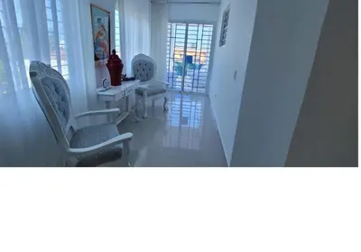 a hallway with chairs and a table and windows at Charming 2BR Apt Near Beach in Sabana Grande