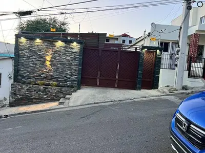 a brick wall next to a fence with a gate at lugar comodo y barato in Santiago de los Caballeros