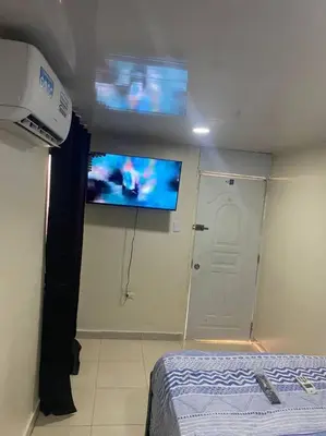 a room with a bed and a flat screen tv at lugar comodo y barato in Santiago de los Caballeros