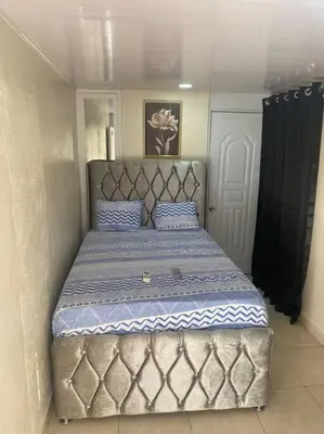 a large bed in a bedroom with a large headboard at lugar comodo y barato in Santiago de los Caballeros