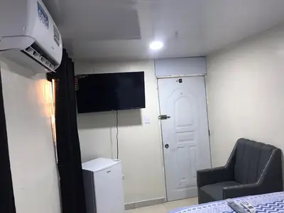 a room with a tv and a chair and a door at lugar comodo y barato in Santiago de los Caballeros