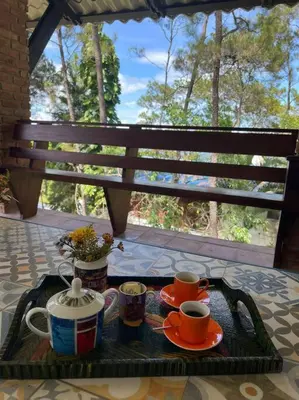 a tray with cups of coffee on a table with a bench at Villa Carmen en Jarabacoa in La Represa