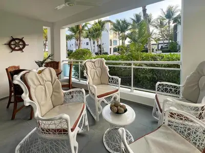 a room with chairs and a balcony with palm trees at A private cozy-beach apartment in Dominicus in La Laguna