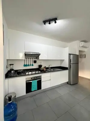 a kitchen with white cabinets and a stainless steel refrigerator at A private cozy-beach apartment in Dominicus in La Laguna
