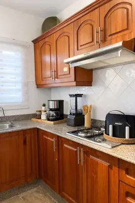 a kitchen with wooden cabinets and a stove top oven at Apartamento en Punta Cana, White sands in Punta Cana