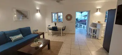 a living room with a blue couch and a table at Beachfront Unit with Stunning Sunsets and Starlink Internet ! in Las Terrenas