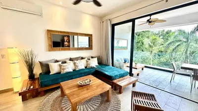 a living room with a couch and a table at All-New Zen Apartment with TreeTops and Ocean Views ! in Las Terrenas