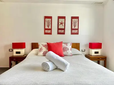 a bedroom with a bed with red pillows and two lamps at Beachfront complex 3BD 3BA with pool in Las Terrenas