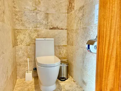a bathroom with a white toilet in a room at Beachfront complex 3BD 3BA with pool in Las Terrenas