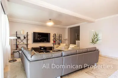 a living room with a couch and a tv at Hispaniola Beach Official, Sosua! in Sosúa
