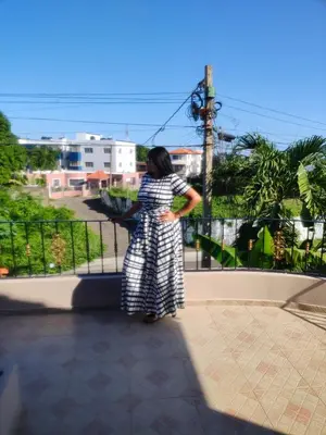 a woman in a dress standing on a balcony at My home in San Felipe de Puerto Plata