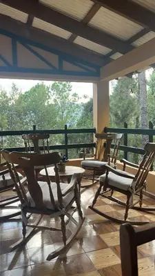 a group of chairs and tables on a porch at Vintage Cabin GB in Constanza