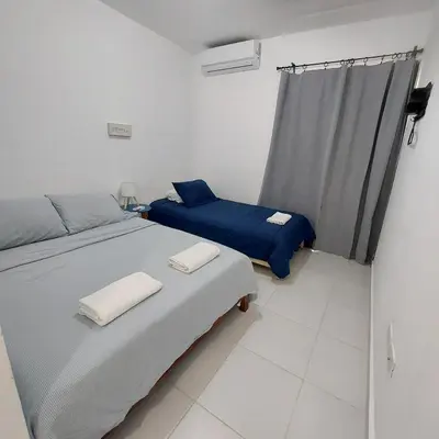 a bedroom with two beds and a window at Santo Domingo Este in Ensanche Savica de Mendoza