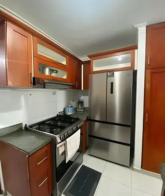 a kitchen with wooden cabinets and a stainless steel refrigerator at Stylish 3BR,2BA in Santo Domingo Este in Mendoza
