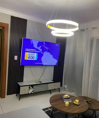 a living room with a tv and two tables at Stylish 3BR,2BA in Santo Domingo Este in Mendoza