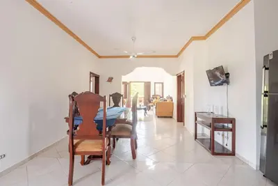 a man sitting in a chair in a living room at Eden House in Río San Juan