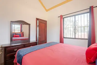 a bedroom with a bed and a mirror and a window at Eden House in Río San Juan