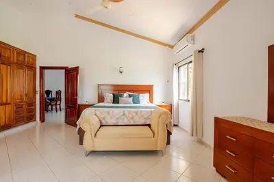a bedroom with a bed and a chair in it at Eden House in Río San Juan