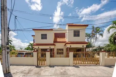 a white house with a gate and fence at Eden House in Río San Juan