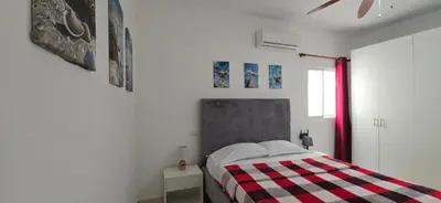 a bedroom with a bed with a checkered blanket at Apartamentos confortables in La Barbacoa