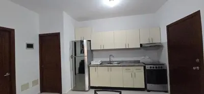 a kitchen with white cabinets and a stainless steel refrigerator at Apartamentos confortables in La Barbacoa