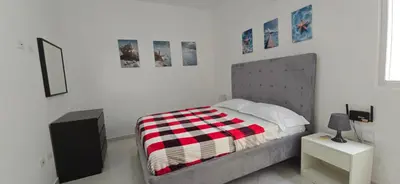 a bedroom with a bed with a red and white blanket at Apartamentos confortables in La Barbacoa