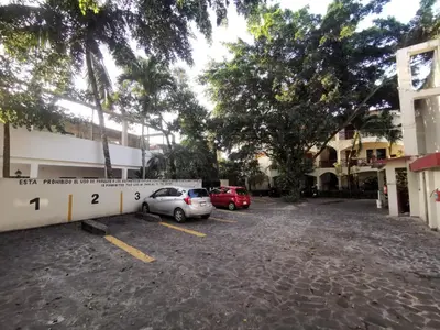 a parking lot with two cars parked in front of a building at Apartamentos confortables in La Barbacoa