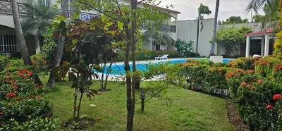a swimming pool in a yard with flowers and trees at Apartamentos confortables in La Barbacoa