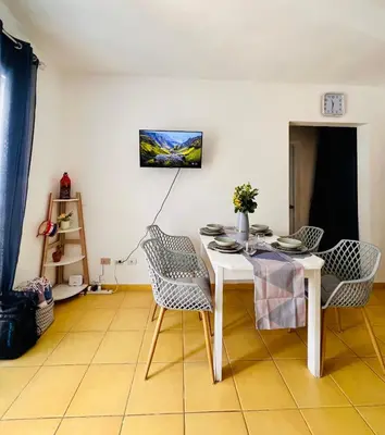 a dining room with a white table and chairs at Apartamento Aurora in Bayahibe