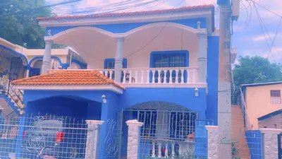 a blue and pink house with a balcony at Casita Azul in Isabel de Torres