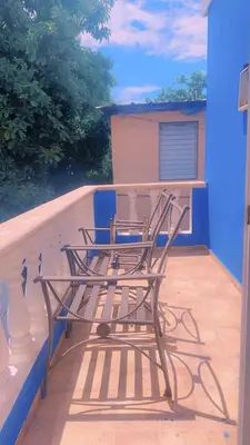 a chair sitting on the back of a balcony at Casita Azul in Isabel de Torres