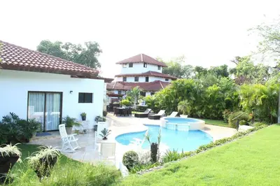 a backyard with a swimming pool and a house at Villa Cajuiles 13, Casa de Campo in La Romana