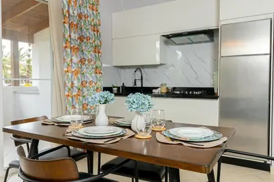 a kitchen with a wooden table with plates and chairs at Charming 1 Bedroom in Tamarindo Dominicus With Pool in La Laguna