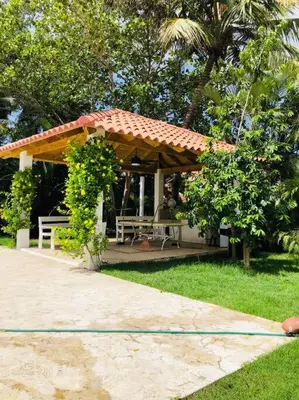 a gazebo with a bench and a table at Hermosa villa en metro country club Juan dolio in Paraíso