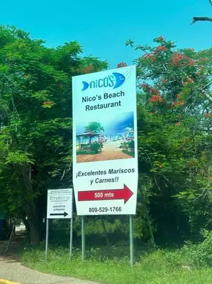 a sign for a macotech beach restaurant next to a tree at Hermosa villa en metro country club Juan dolio in Paraíso