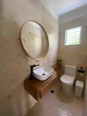 a bathroom with a sink and a mirror and a toilet at Hermosa villa en metro country club Juan dolio in Paraíso